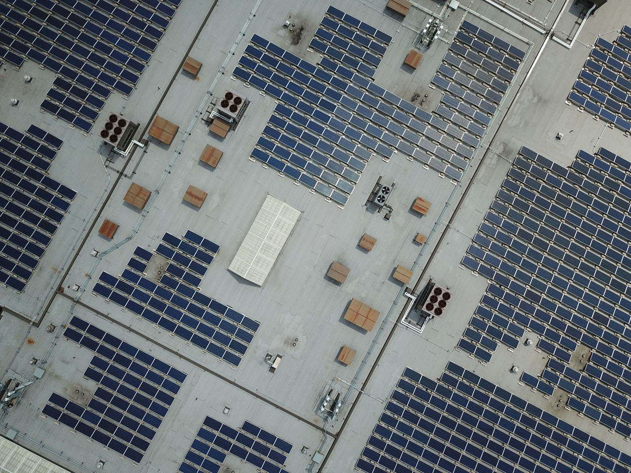 Mastering the First Impression: Your intriguing post title goes here High-angle aerial shot of a large rooftop solar panel array on an industrial building.